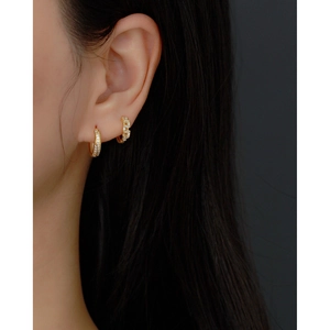 Gros plan de boucles d'oreilles s925 en argent doré avec zircons sur un modèle