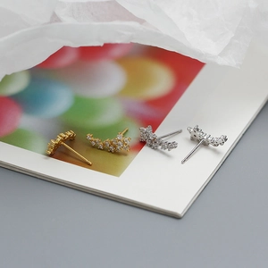 Macro shot of s925 silver flower stud earrings with tiny pavé diamonds on artistic paper