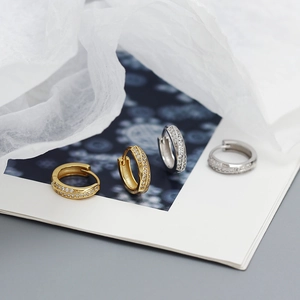 Vue détaillée des boucles d'oreilles Möbius en argent poli avec incrustation de zircon