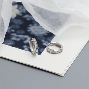 Détail des boucles d'oreilles Mobius en argent avec micro-pavage de zircons cubiques