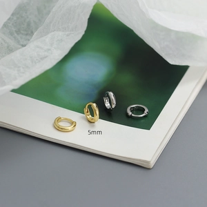 Macro shot of 5mm S925 sterling silver mini hoop earrings in gold and silver finish
