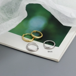 Detailed view of 9mm minimalist gold and silver hoop earrings on a display
