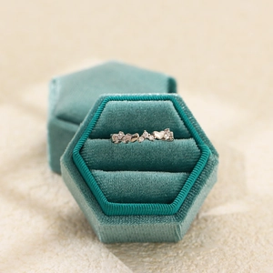 Close-up of s925 sterling silver heart diamond ring in a luxury green velvet gift box