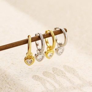 Macro detail of S925 sterling silver heart earrings with gold plating and zircons