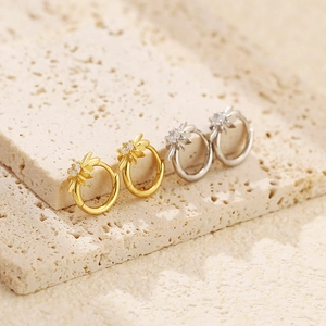 Macro view of gold and silver S925 sterling silver star hoop earrings on stone base