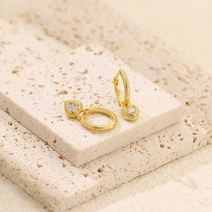 Macro shot of S925 silver stamp on gold heart earrings with twisted hoop and zircons