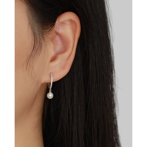 Gros plan d'une boucle d'oreille en argent S925 avec cristaux et perle blanche pendante