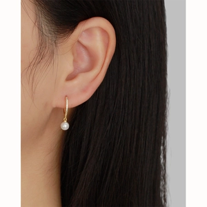 Détail de boucle d'oreille en argent s925 avec perle et oxydes de zirconium sur l'oreille