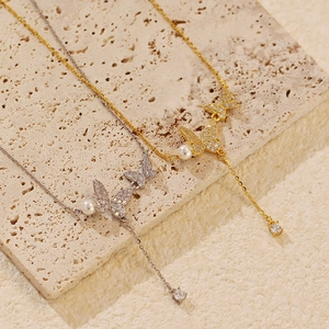 Elegant butterfly pendant necklace with pearls and sparkling crystals in gold and silver