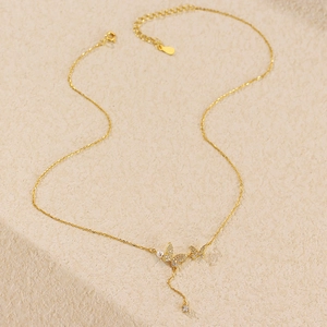 Close-up of golden butterfly necklace with pearls, tassels, and sparkling zircons