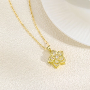 Detail view of double-layered gold flower pendant with sparkling cubic zirconia on fine chain