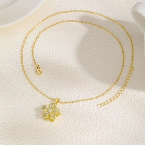Detailed view of gold flower necklace with pink zircon spinning petals and lobster clasp