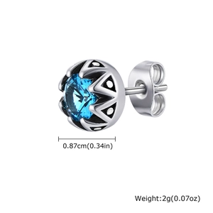 Détails macro des boucles d'oreilles couronne en acier titane et zircon bleu