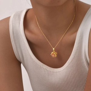 Close-up of golden flower pendant necklace with colorful zircons on a model