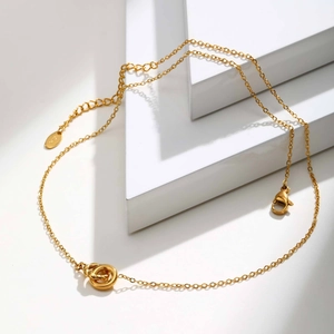 Detailed view of intertwined golden rings necklace with lobster clasp and S925 tag