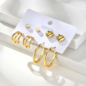 Details von vierteiligem goldenem Ohrring-Set mit Creolen, Herzsteckern und Zirkon