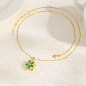 Detail of gold floral necklace with emerald green petals and adjustable lobster clasp