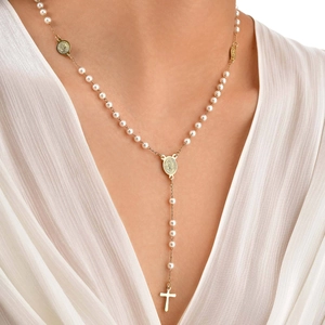 Dettaglio di una collana a Y dorata in acciaio inossidabile con perline, croce e medaglia