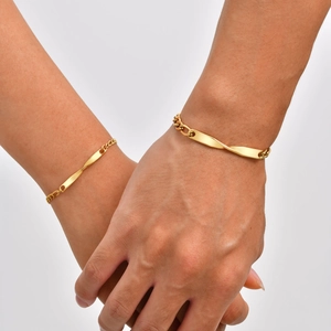 Minimalist gold-plated stainless steel Mobius strip couple bracelets on a male and female wrist