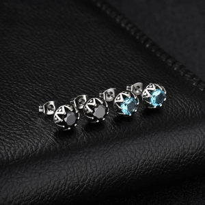 Vue macro de boucles d'oreilles en titane avec zircons bleus et noirs sertis