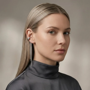 Close-up of a silver non-pierced ear cuff with long flowing metal tassels on a model