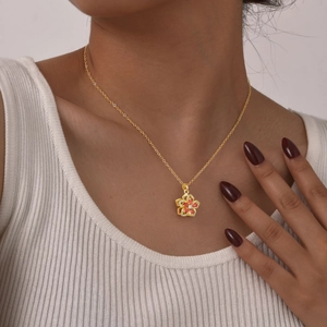 Elegant gold flower necklace for women with pink zircon petals worn by a model