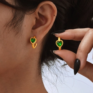 Detailopname van 18K vergulde oorringen met een groene hartvormige zirkonia steen