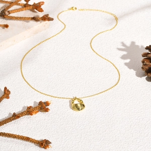 Detail of 18K gold irregular hollow pendant necklace with pine cones and pine branches