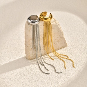 Gold and silver tassel ear cuffs in minimalist stainless steel displayed on stones
