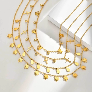 Detailsicht der goldenen Edelstahl-Halsketten mit Kleeblatt- und Schmetterlingsanhängern