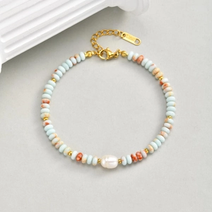 Detail of beaded bracelet with blue stones, baroque pearl and gold lobster clasp