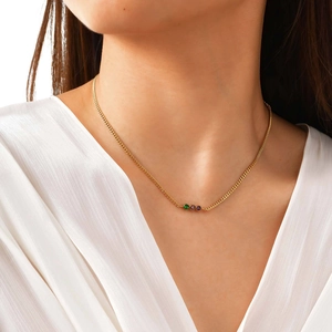 Collana a catena cubana in acciaio dorato con tre zirconi colorati indossata dal modello
