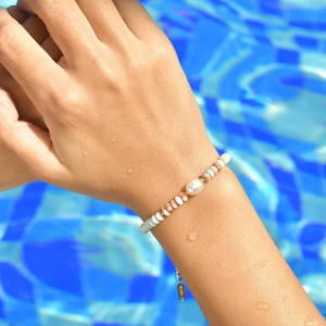 Stainless steel beaded bracelet with baroque pearl and colorful discs on model wrist