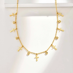 Detailaufnahme der goldenen Edelstahlkette mit Kreuzanhängern und Zirkonia-Steinen