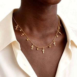 Detailansicht der goldenen Kreuzkette mit Zirkonia-Anhängern an einem Model getragen