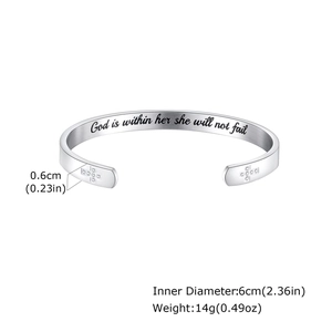 Macro shot of silver stainless steel cuff showing engraved quote and cross details