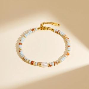 Beaded stainless steel bracelet with blue and marble beads and a white opal centerpiece