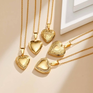 Detailed view of assorted gold heart locket necklaces with floral engraving and crystals