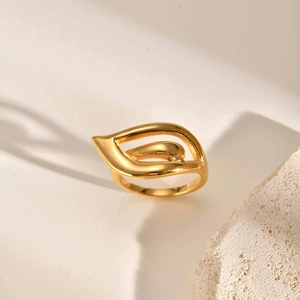 Detailed close-up of an 18K gold hollow wing teardrop ring on a natural stone base