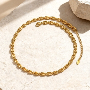 Detail van 18K vergulde ketting met karabijnsluiting en K18-label op stenen voet