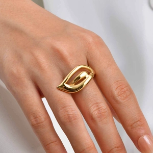 Macro detail of abstract hollow wing ring in 18K gold finish on a model hand