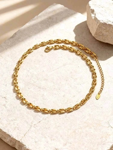 Detail van 18K vergulde rechthoekige schakels en de K18-markering op de gouden ketting
