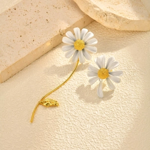Boucles d'oreilles marguerite dorées avec pétales blancs sur fond de pierre naturelle
