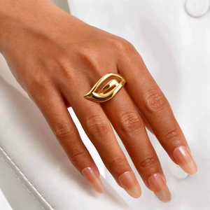 Modern 18K gold hollow wing teardrop ring for women on white soft leather background