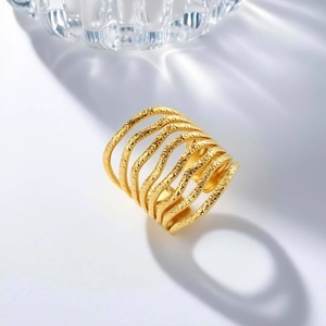 Macro view of gold stainless steel multi-layer wavy ring with textured finish