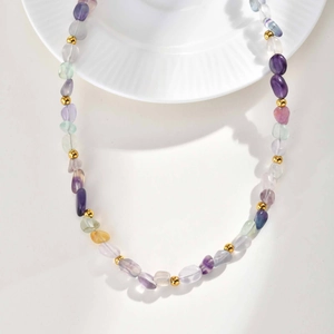 Macro detail of natural translucent stones and gold metal beads on stainless steel chain