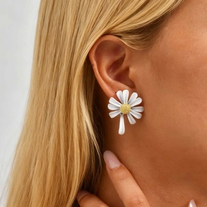 Gros plan sur des boucles d'oreilles marguerites dorées portées par un mannequin