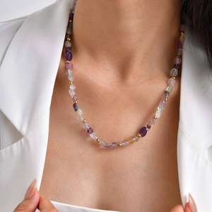 Natural gemstone chip necklace with stainless steel gold beads on a model wearing white