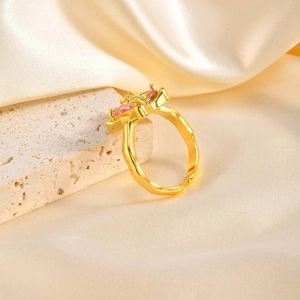 Detail of adjustable gold ring with pink heart and gold star on silk fabric