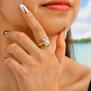 Detail of adjustable gold ring featuring a large rectangular zircon and star accents